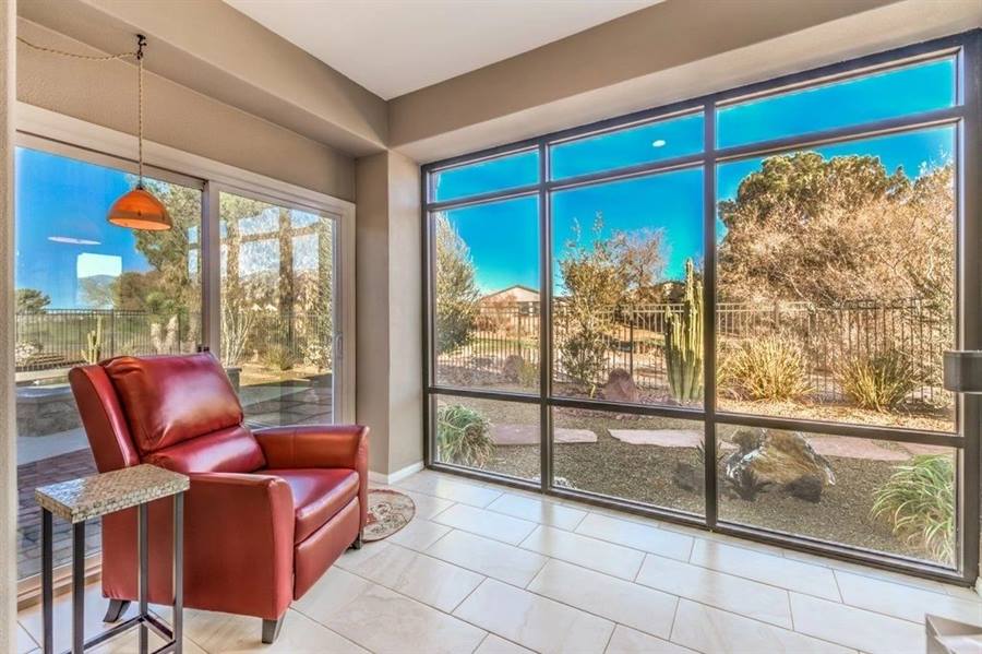 Sunroom with a full-height window wall looking onto desert landscaping and cactus