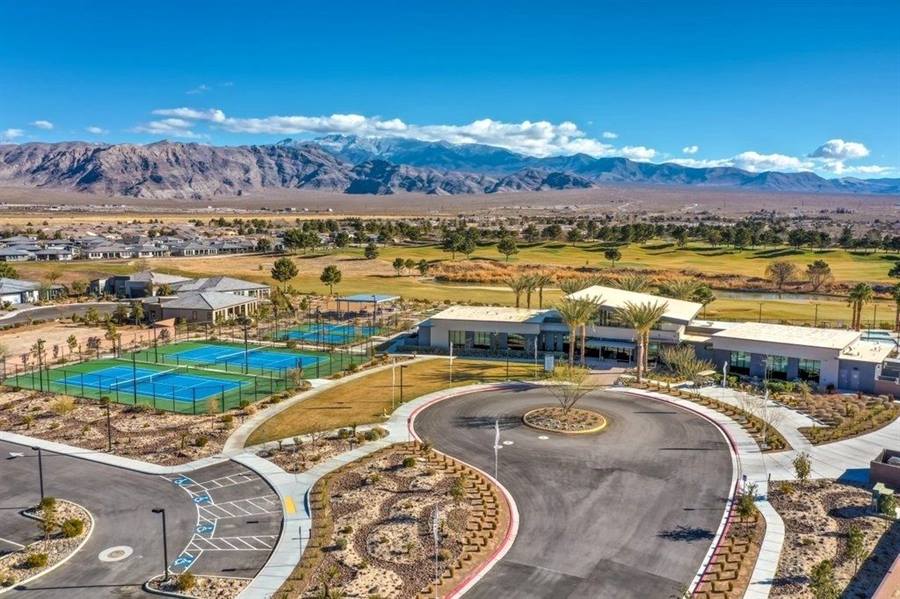 Community clubhouse and courts with snow-capped mountains rising behind the valley